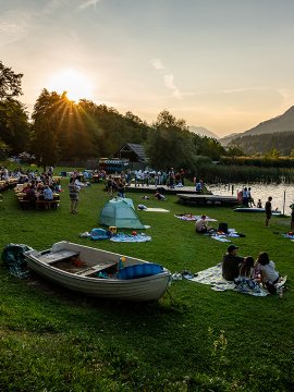 Summer event by lake with picnic blankets and boats